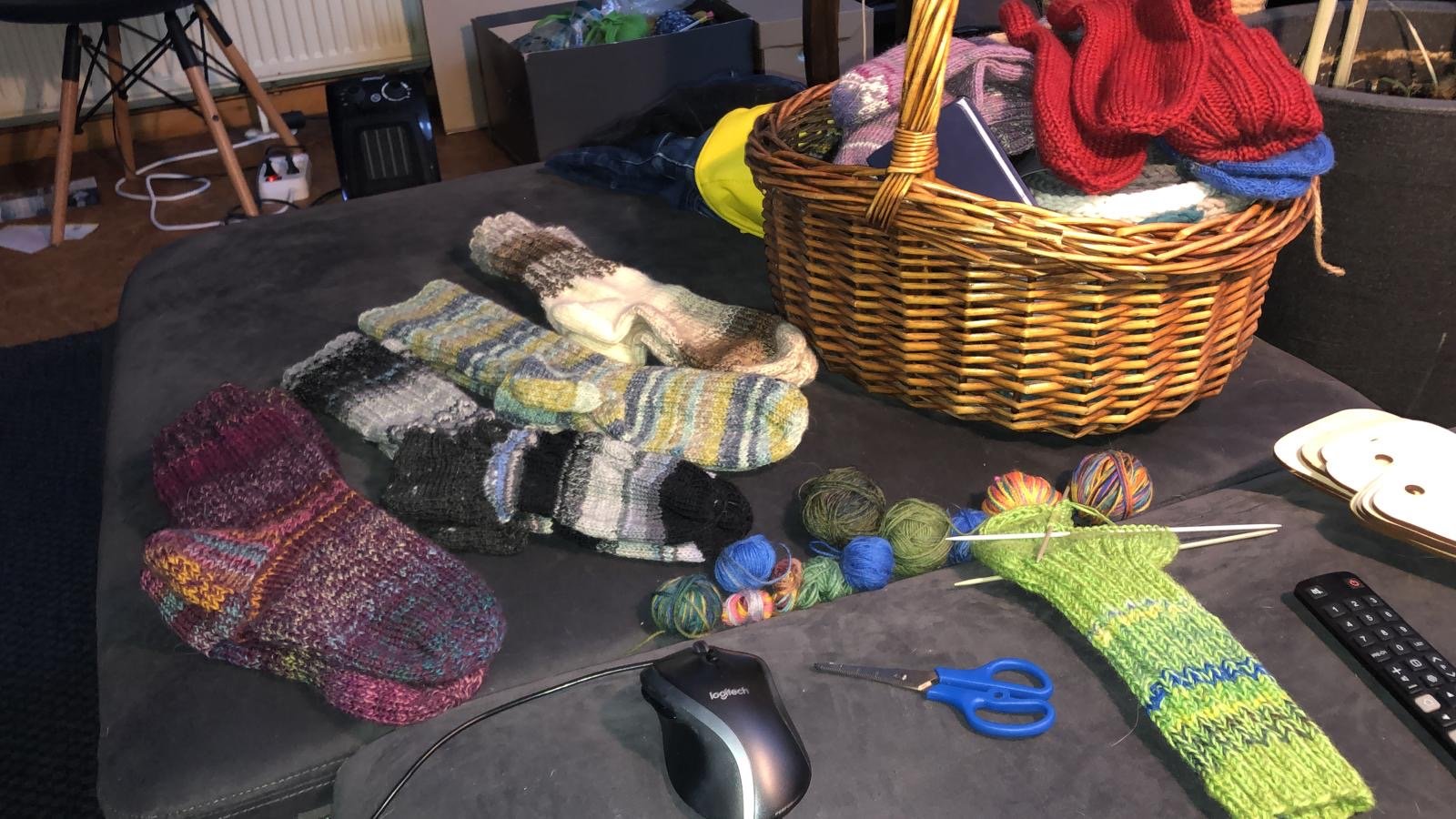 Arbeitstisch mit Strickstücken und Garn